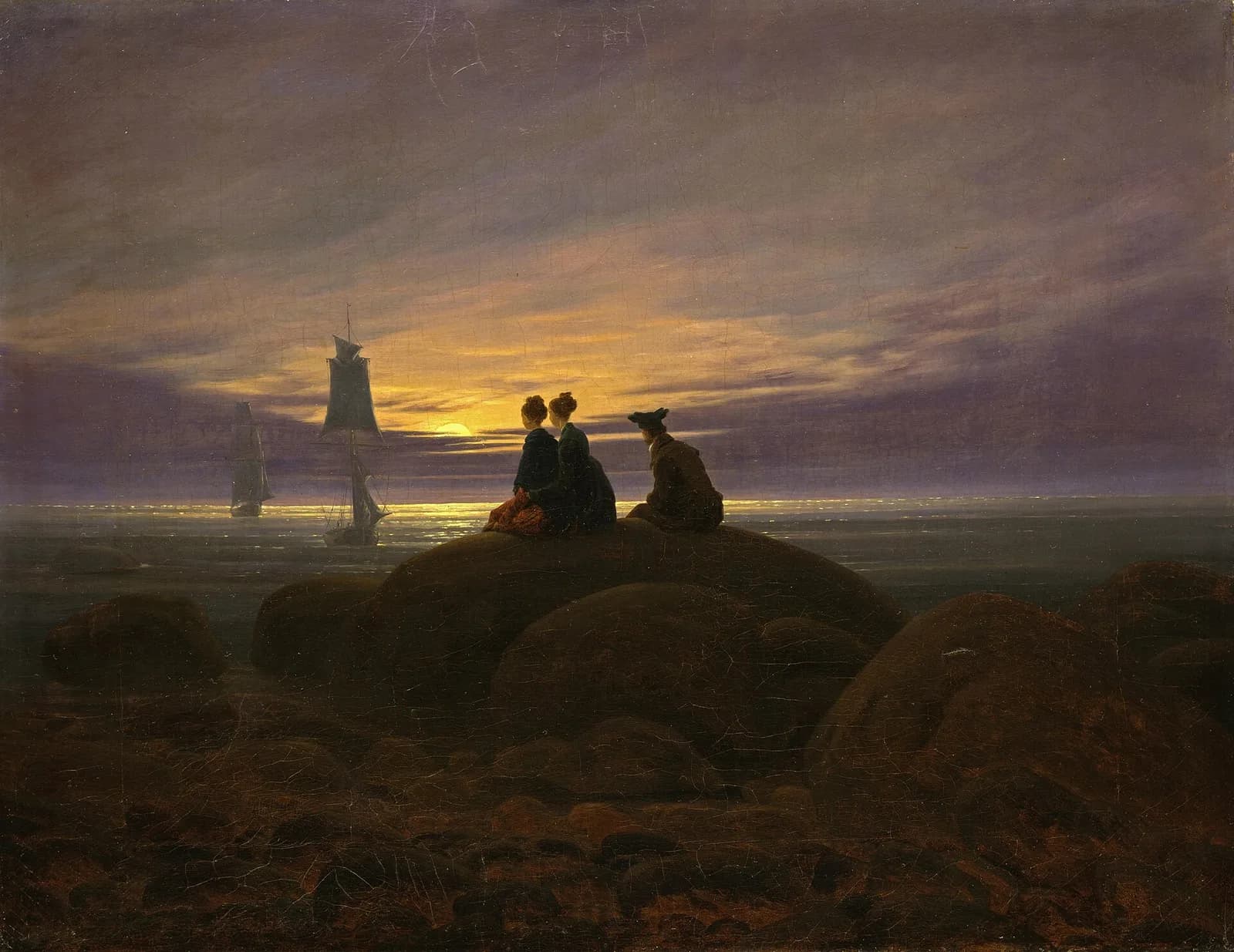 Painting by Caspar David Friedrich: three people seated on a rock at the shore, seen from behind, watching two sailing ships and the moon rising over the water.